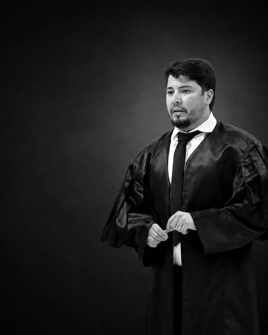 Erinaldo Santos de beca, em retrato profissional preto e branco.